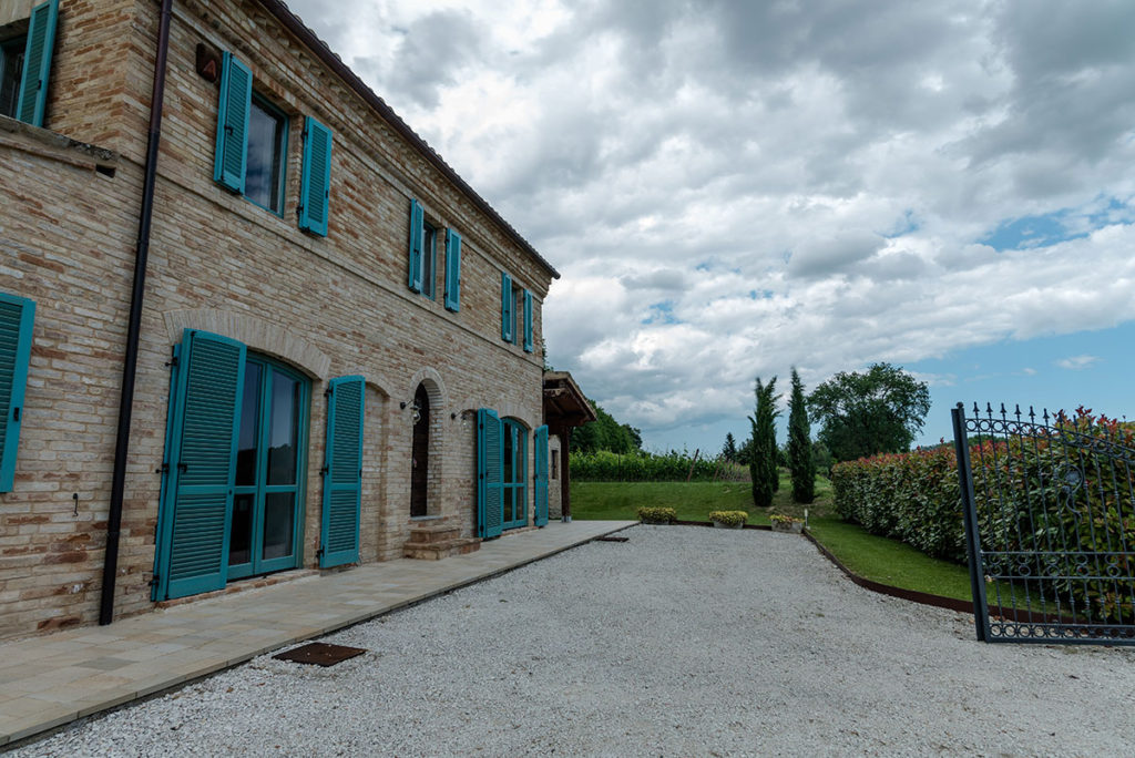 Stone façade and gravel parking area at Casale Vigneto